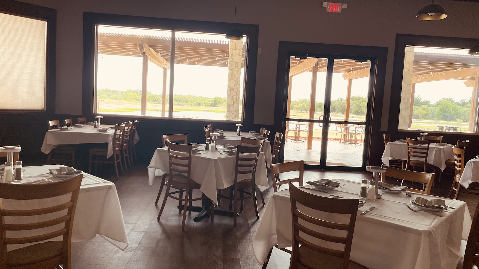 Elegant dining room at Morea Italian Steakhouse with white tablecloths and golf course views